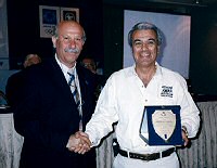 Evaggelos Papapostolou, Technical Director of the Athens Classic Marathon, presenting Paul Samaras with an award for promoting the event.